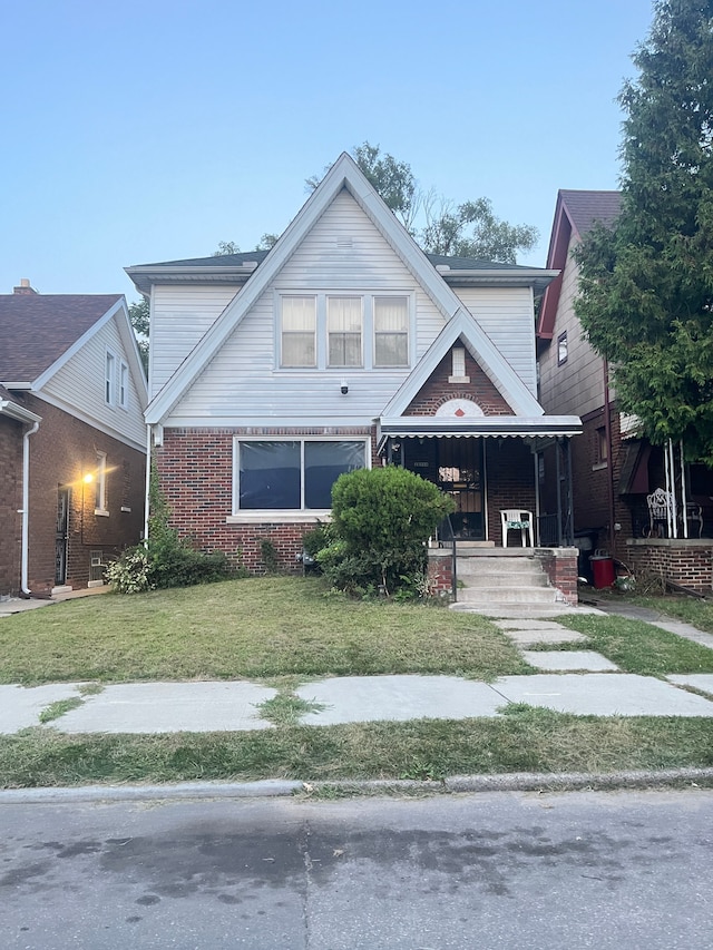 view of front of home with a front yard and brick siding