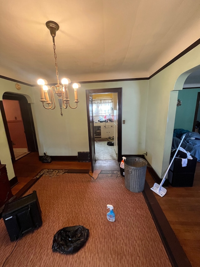 unfurnished dining area featuring an inviting chandelier and hardwood / wood-style flooring