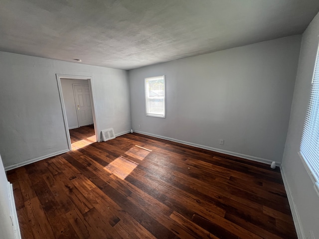 spare room with dark wood-type flooring