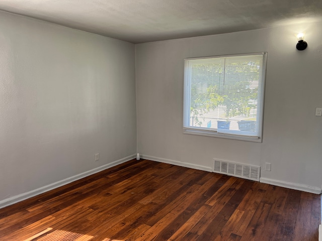 empty room with dark wood-type flooring