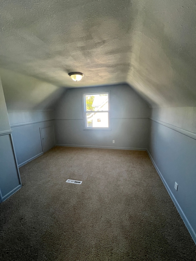 bonus room featuring carpet flooring, a textured ceiling, and vaulted ceiling