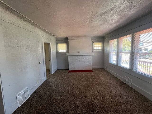 15361 Wisconsin St, Detroit, MI 48238 - unfurnished living room featuring a textured ceiling, carpet flooring, a brick fireplace, and baseboards