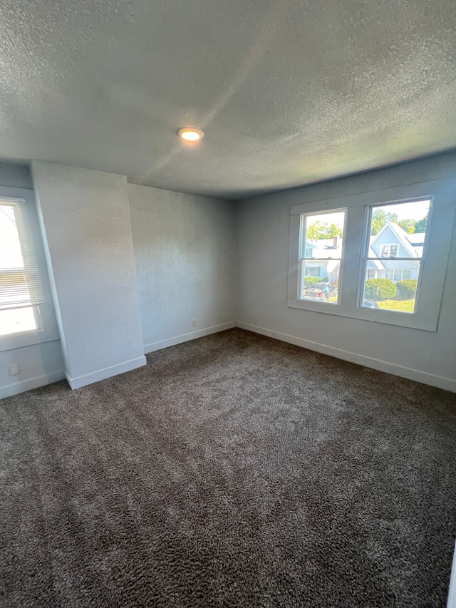 spare room featuring carpet floors and a textured ceiling