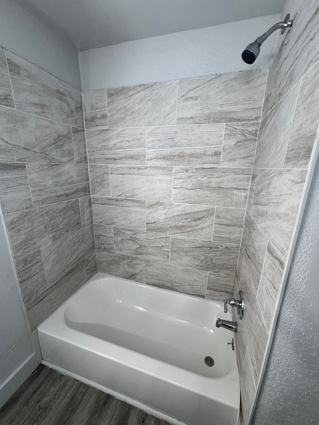 bathroom with wood-type flooring and tiled shower / bath combo