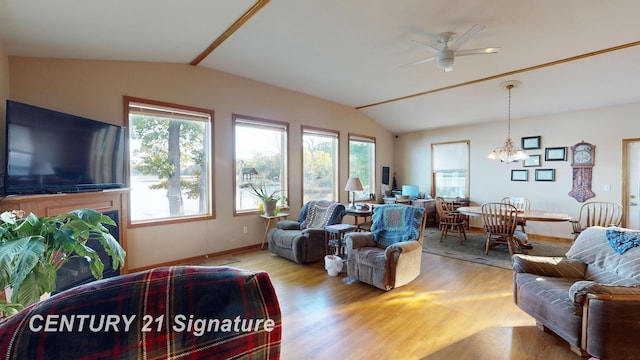 living room with ceiling fan with notable chandelier, lofted ceiling, wood finished floors, and baseboards