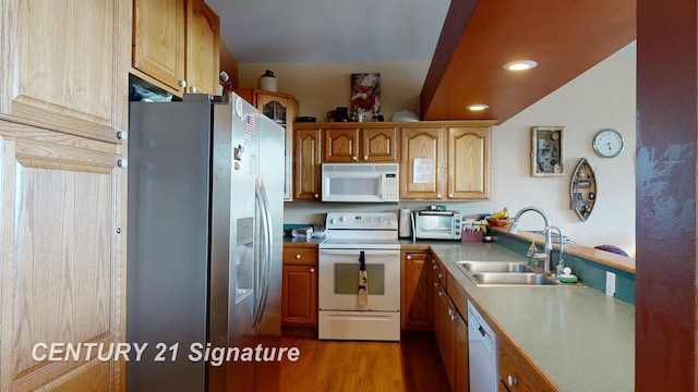 kitchen featuring white appliances, wood finished floors, recessed lighting, a sink, and light countertops