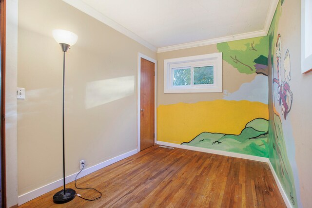 unfurnished bedroom featuring crown molding and wood-type flooring