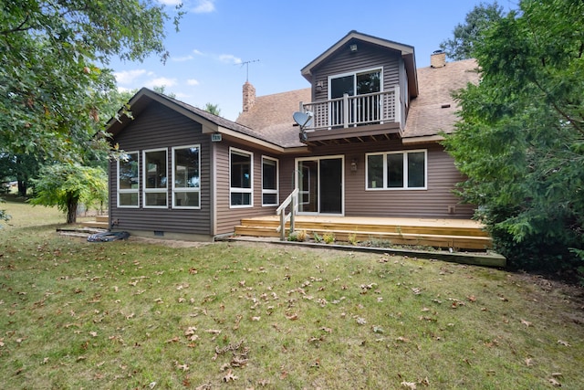 rear view of house with a balcony and a yard