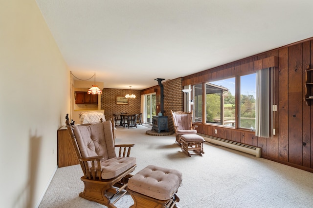 living area featuring carpet, baseboard heating, brick wall, and wood walls