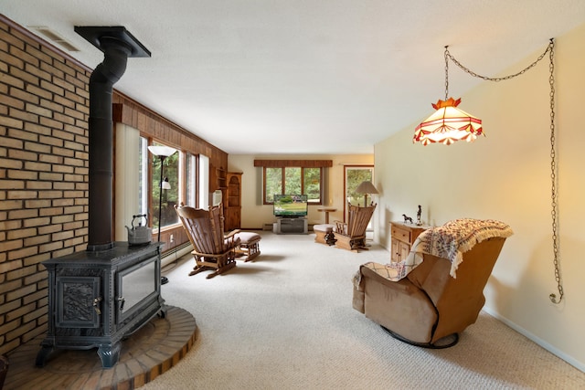 carpeted living room featuring a baseboard heating unit, wood walls, and a wood stove