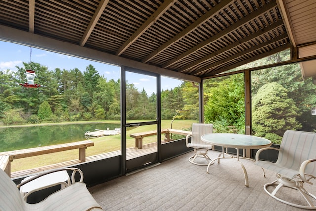 sunroom featuring a water view