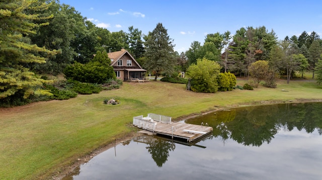 view of dock with a water view and a lawn