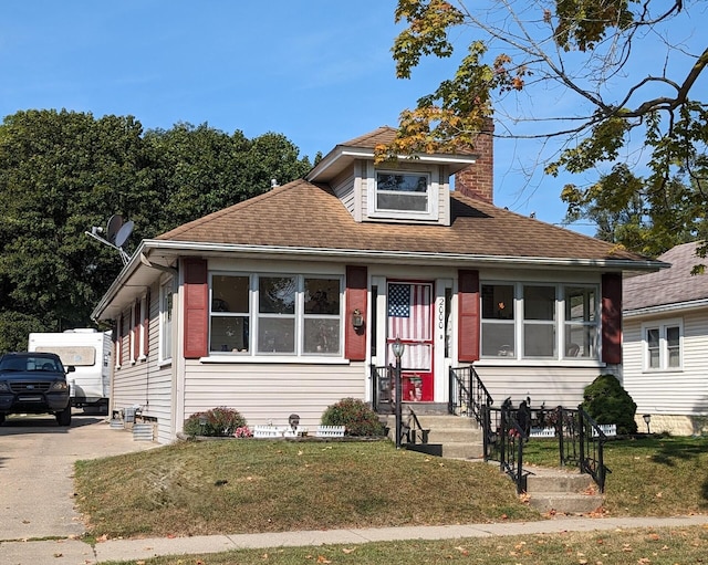 bungalow-style home featuring a front lawn