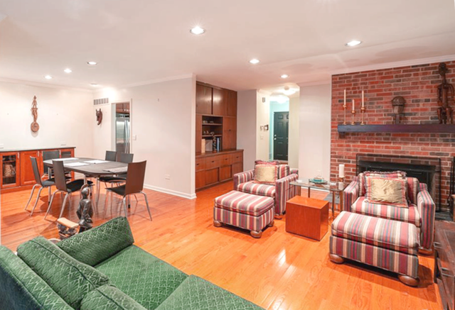 living room featuring crown molding, a fireplace, and light hardwood / wood-style flooring