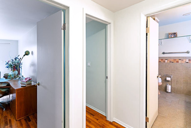 corridor with hardwood / wood-style flooring and tile walls