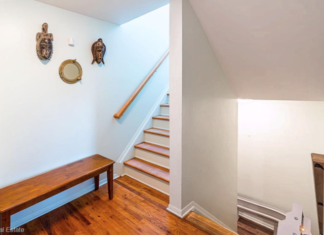 stairway featuring hardwood / wood-style flooring and lofted ceiling