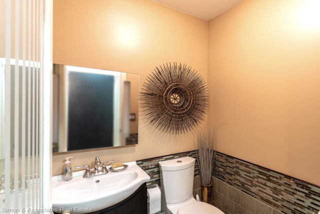 bathroom with tile walls, vanity, and toilet