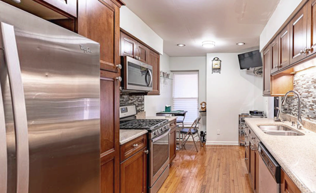 kitchen with tasteful backsplash, stainless steel appliances, light hardwood / wood-style floors, and sink