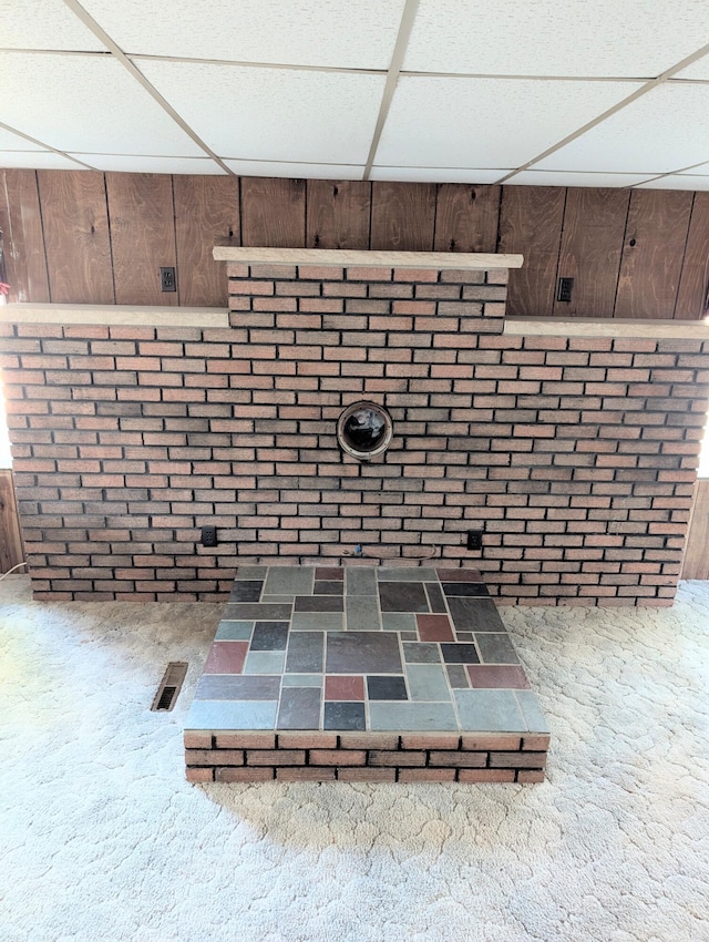 11700 Stultz St, Rockford, MI 49341 - detailed view of carpet floors, a drop ceiling, wood walls, and brick wall