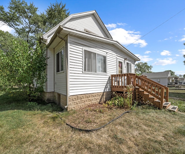 view of home's exterior featuring a deck and a yard