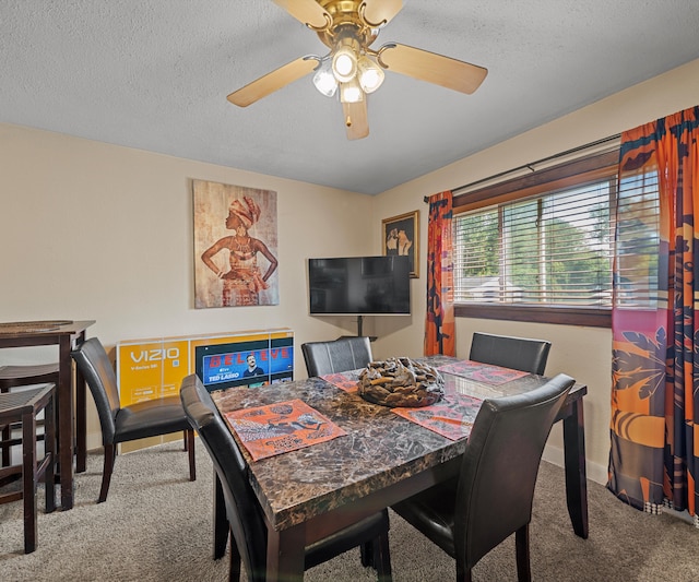 carpeted dining space with ceiling fan and a textured ceiling