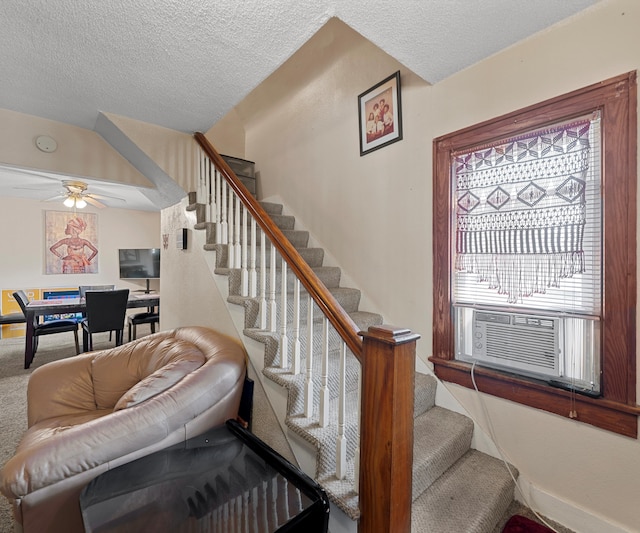 stairway with carpet, a textured ceiling, ceiling fan, and cooling unit