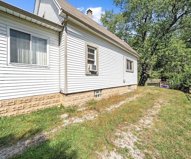 view of side of property with a yard and cooling unit