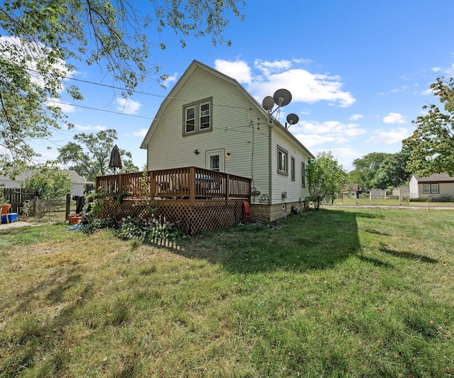 back of property with a yard and a wooden deck