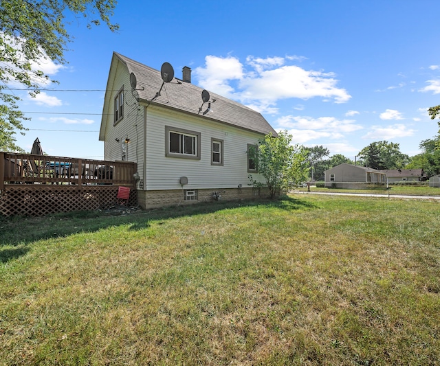 back of property with a yard and a wooden deck