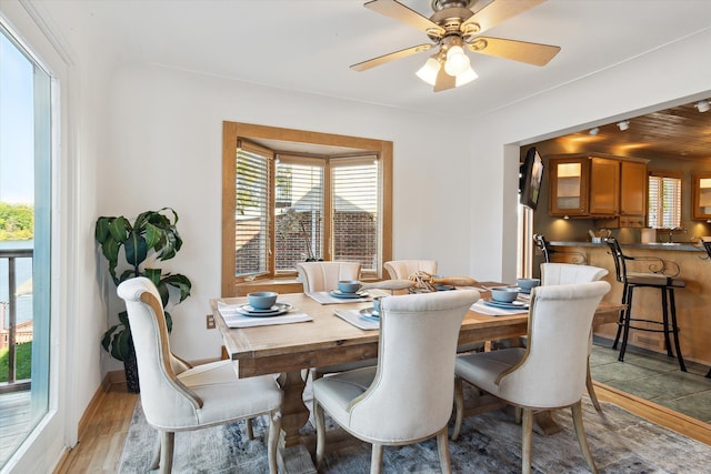 dining space with light hardwood / wood-style flooring, ceiling fan, and wood ceiling