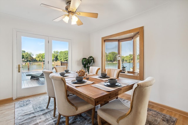 dining space with ceiling fan, a healthy amount of sunlight, and light wood-type flooring