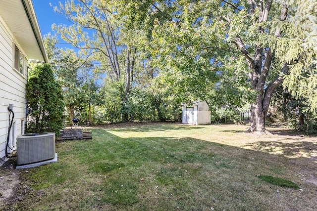 view of yard featuring central AC unit and a shed