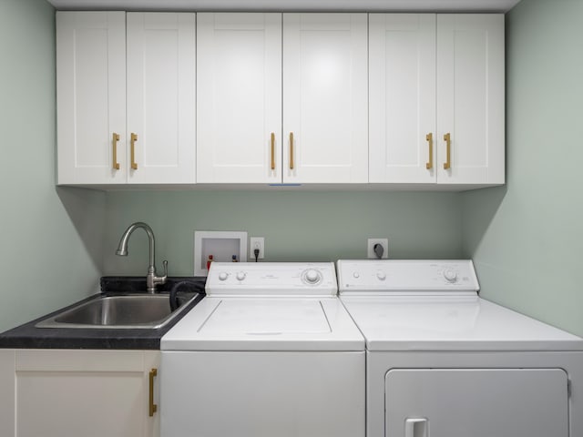 laundry room featuring washing machine and dryer, sink, and cabinets