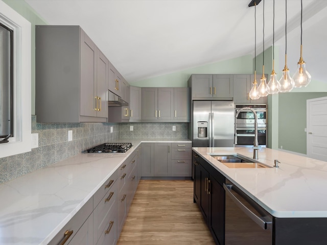 kitchen featuring gray cabinetry, lofted ceiling, hanging light fixtures, tasteful backsplash, and stainless steel appliances