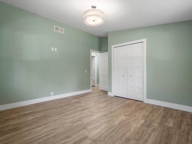 unfurnished bedroom with a closet and light wood-type flooring