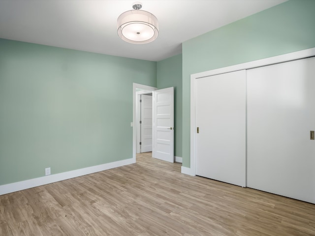 unfurnished bedroom featuring a closet and light hardwood / wood-style floors