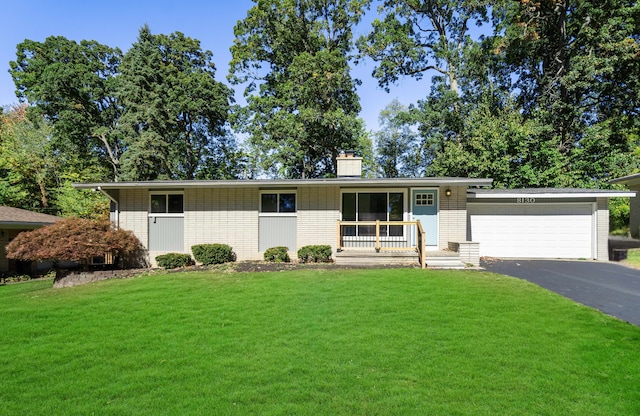 ranch-style house with a front yard, a garage, and covered porch