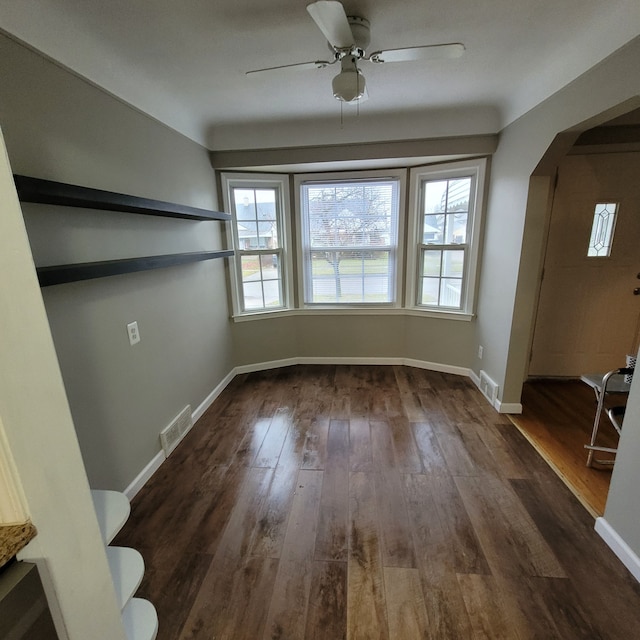 unfurnished dining area with dark hardwood / wood-style flooring and ceiling fan