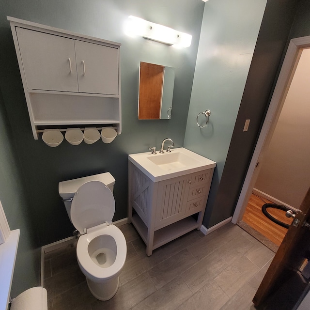 bathroom featuring hardwood / wood-style flooring, vanity, and toilet