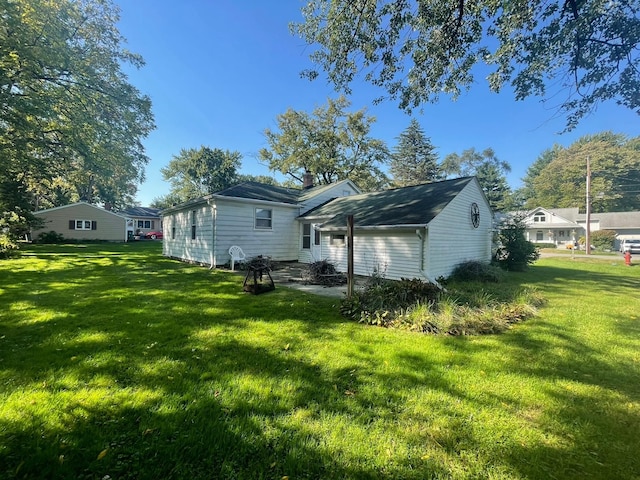 rear view of property featuring a lawn