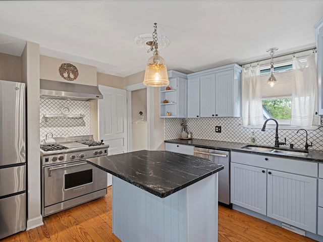 kitchen featuring appliances with stainless steel finishes, a center island, light hardwood / wood-style flooring, and sink