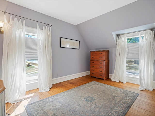 bedroom with vaulted ceiling and light hardwood / wood-style flooring