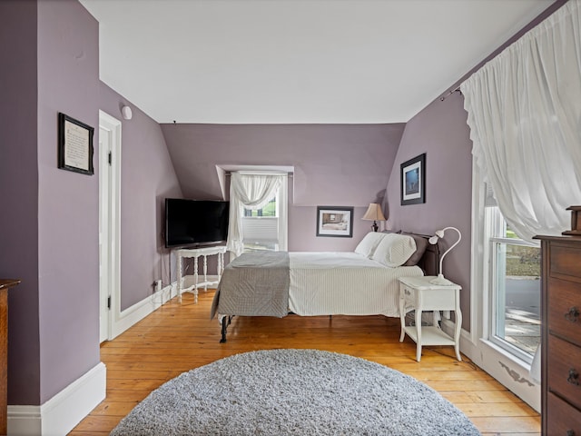 bedroom featuring light hardwood / wood-style floors and vaulted ceiling