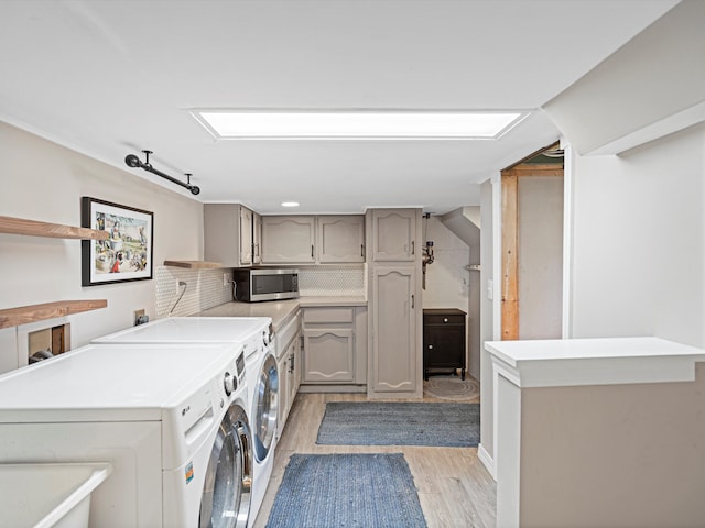 laundry area featuring washer and dryer and light hardwood / wood-style floors