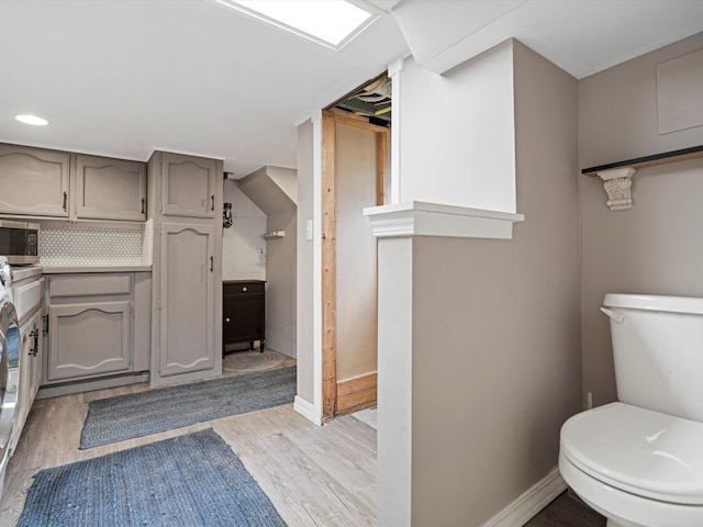 bathroom with hardwood / wood-style floors, vanity, toilet, and tasteful backsplash