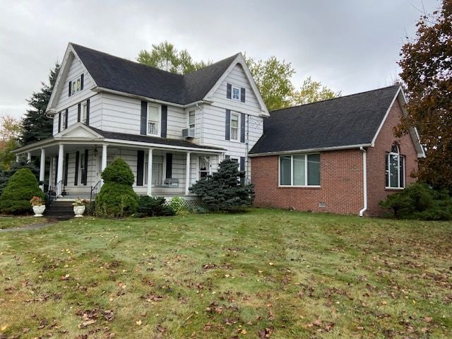 view of front of property featuring a porch and a front lawn