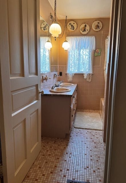 bathroom featuring tile patterned floors, vanity, and tile walls