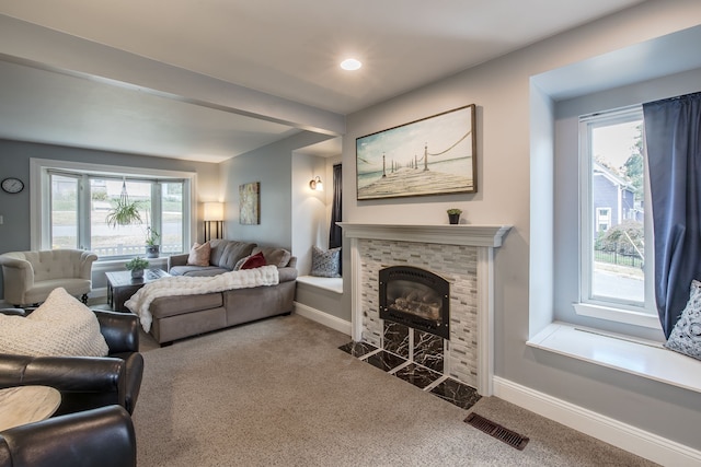 living room featuring carpet flooring and a tiled fireplace