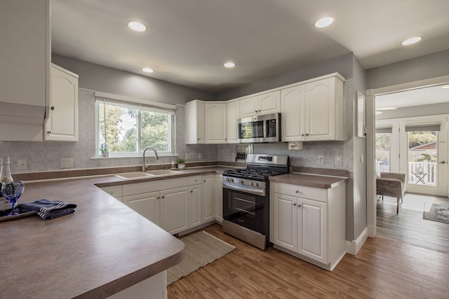 kitchen featuring white cabinets, a healthy amount of sunlight, sink, and appliances with stainless steel finishes