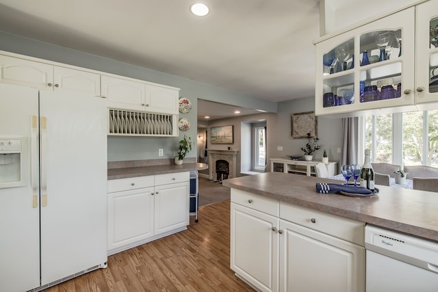 kitchen featuring white cabinets, white appliances, light hardwood / wood-style flooring, and plenty of natural light